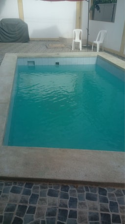 Una piscina al aire libre, sombrillas
