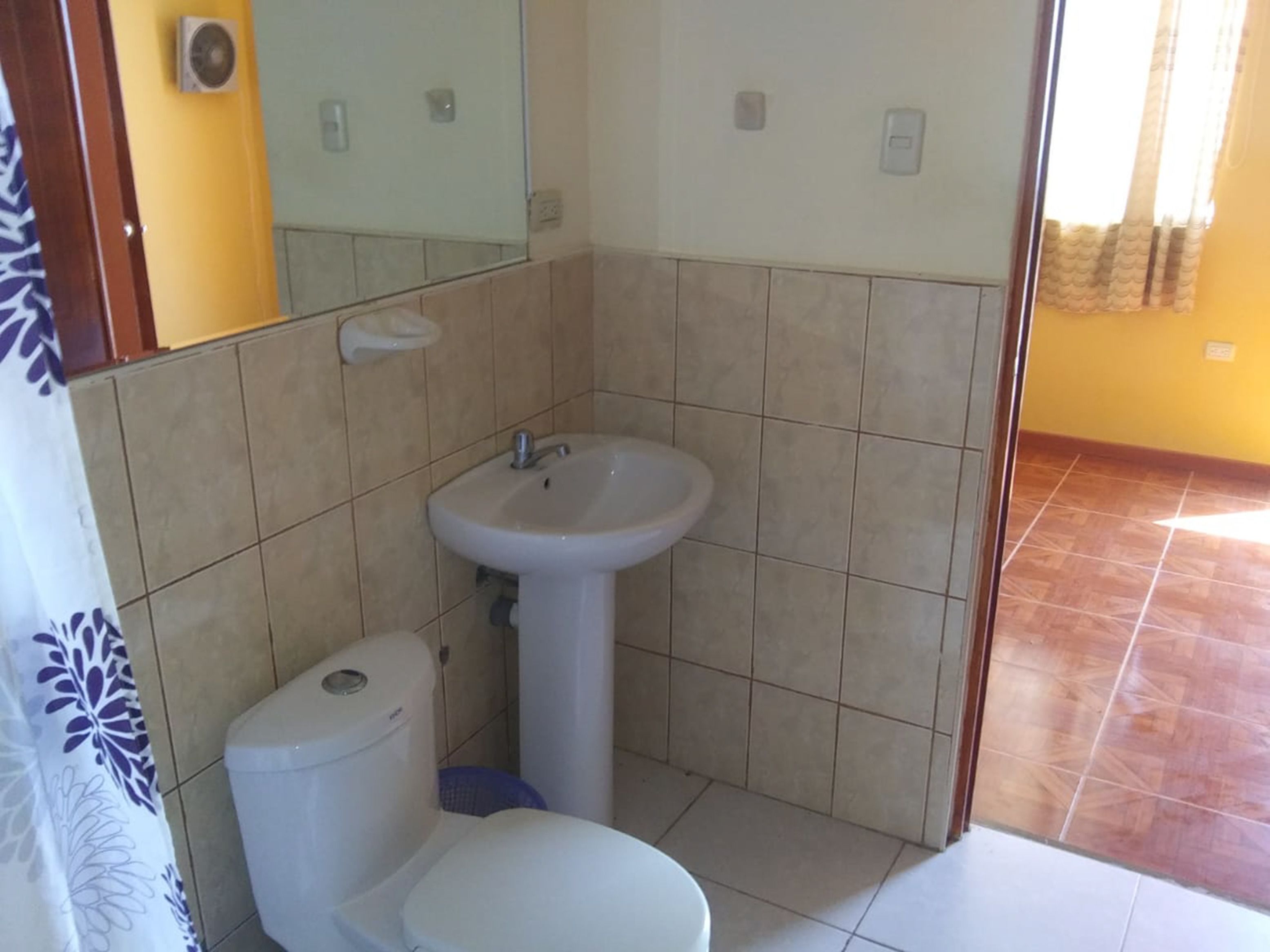 Une petite salle de bain avec des toilettes, un lavabo et un miroir.