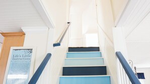 A staircase with blue steps and white walls, leading to a room with a door at the top. - Remodeled 4 BR Waterfront Beach House with all the Comforts of Home...and more! (Clinton)
