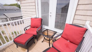 A balcony with two wicker chairs and a glass table. - Remodeled 4 BR Waterfront Beach House with all the Comforts of Home...and more! (Clinton)