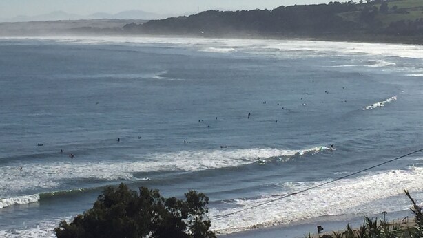 A coastal view with waves and surfers. - Yemanya Hostal (Concon)
