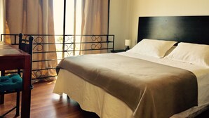 A hotel room with a bed, a desk, and a chair. - Yemanya Hostal (Concon)