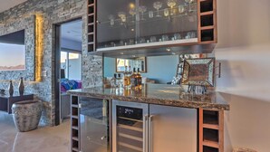 A modern kitchen with a stone accent wall, a built-in wine rack, and a refrigerator with a digital display.