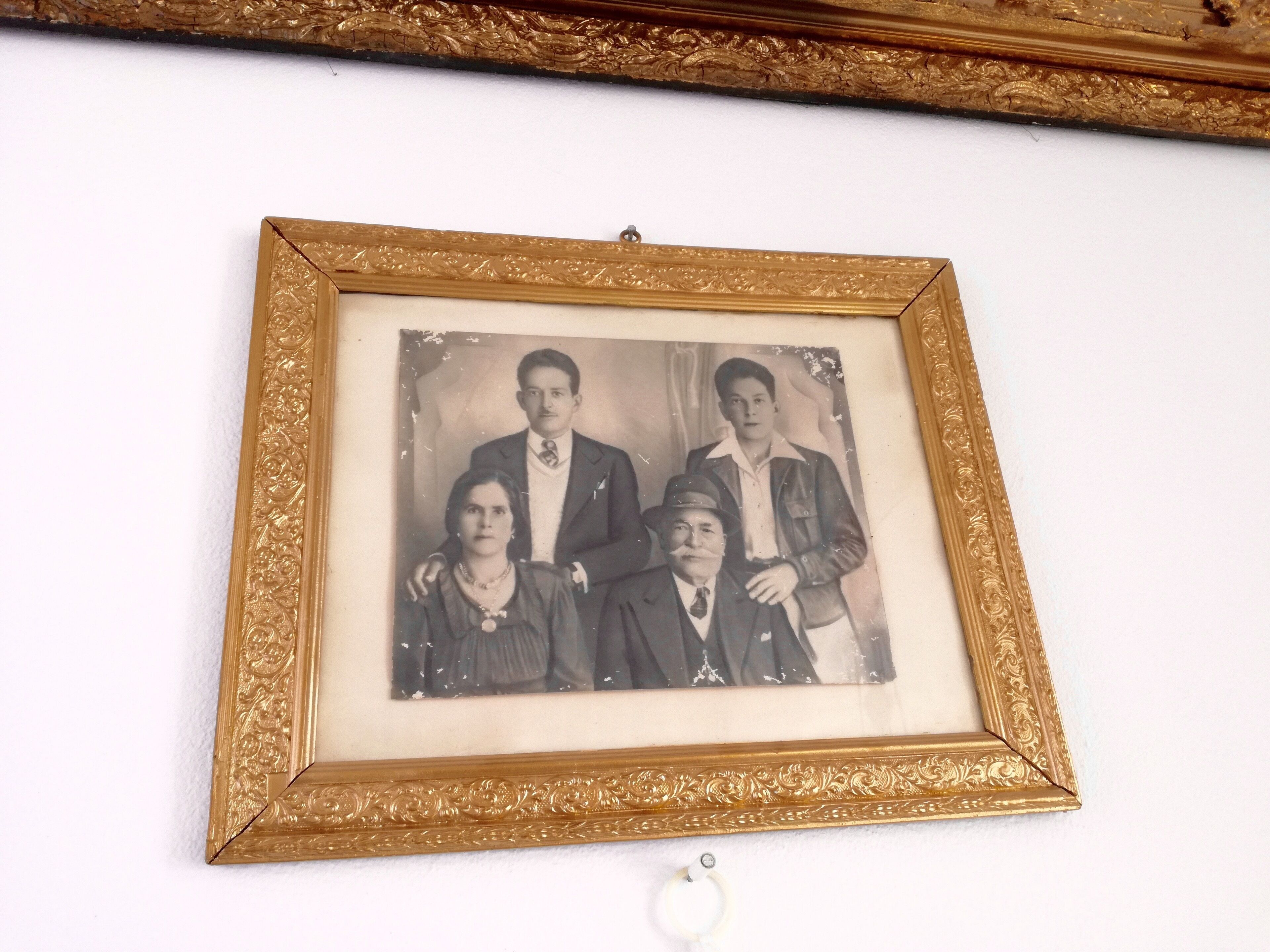 A framed black and white photograph with ornate gold detailing.