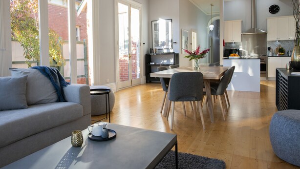 A modern living room with a sofa, coffee table, and dining area. - Charming Historic Home With Modern Interior - In The Heart Of Ballarat (Ballarat Central)
