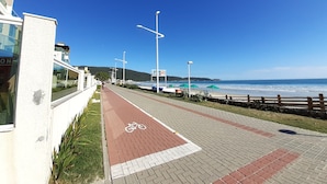 Une promenade en bord de mer avec une piste cyclable, des lampadaires et une vue sur la mer.