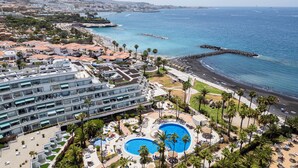 Een resort met meerdere zwembaden, een strand en uitzicht op de oceaan.
