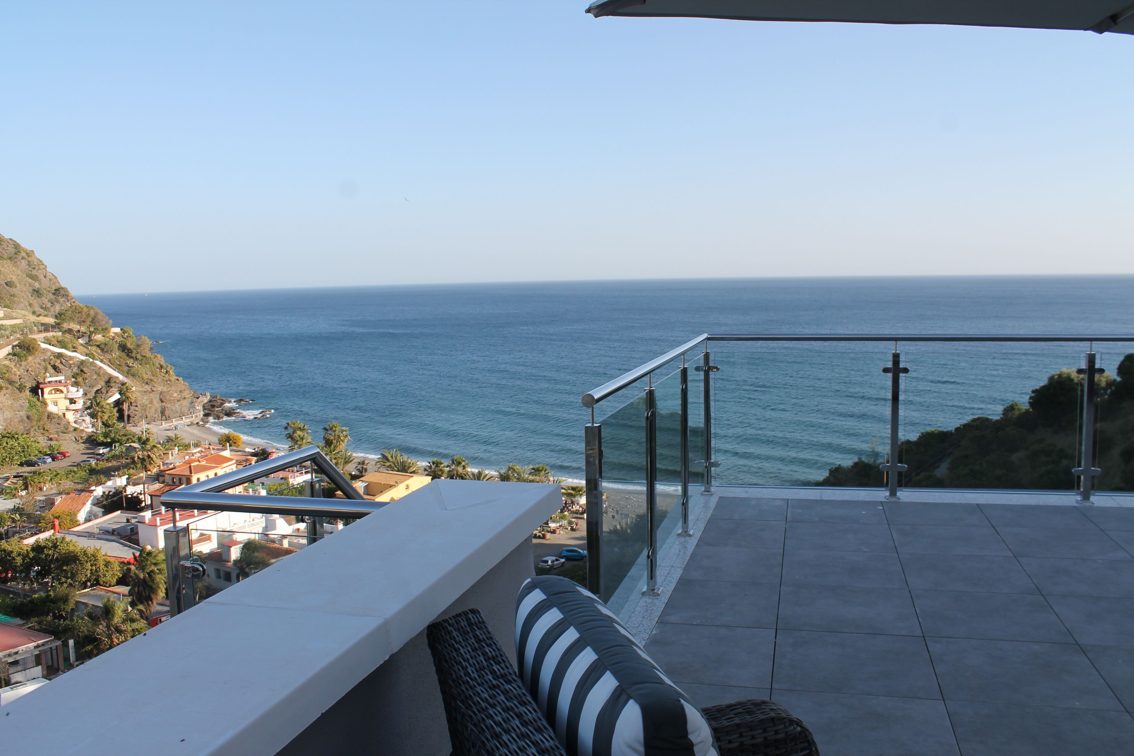 Ein Balkon mit Blick auf das Meer und eine Küstenstadt.