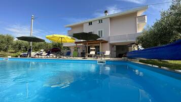 Outdoor pool, a heated pool, pool umbrellas, pool loungers