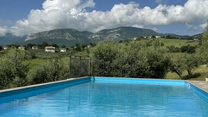 A swimming pool with a view of mountains and houses in the background.