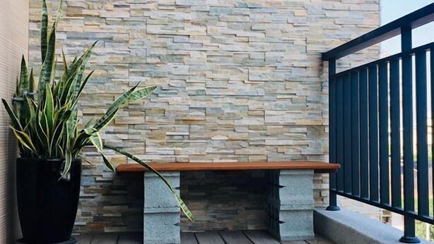 A wooden deck with a stone wall, a bench, and a potted plant. - Come Home Travel (Tainan)