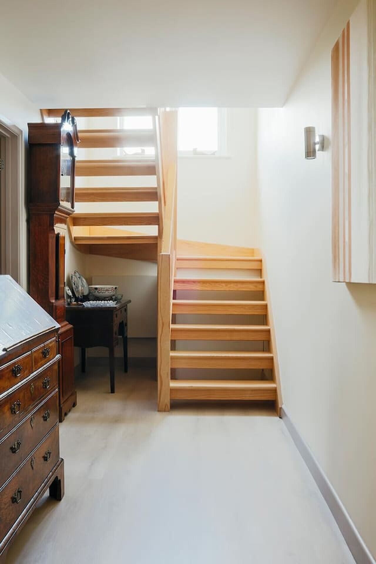 A narrow room with a wooden staircase leading to an upper level.