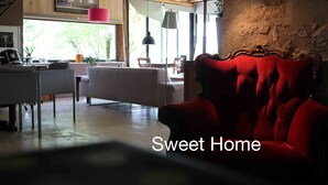 Un salon chaleureux avec un canapé rouge, un fauteuil blanc et une table à manger.