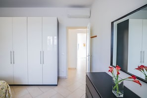 Una habitación moderna con armarios blancos, un tocador y un espejo.