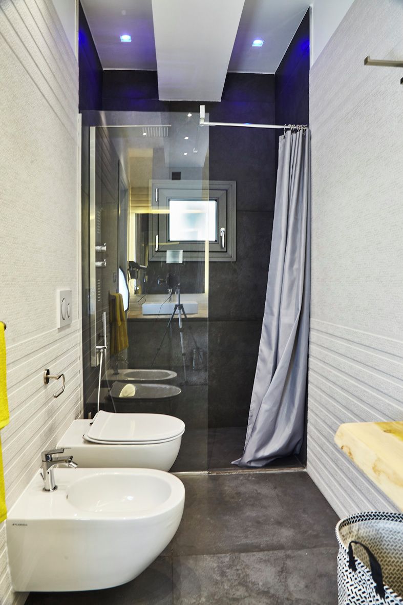 A modern bathroom with a glass shower enclosure, two sinks, and a mirror.
