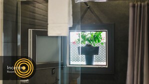 A bathroom with a shower curtain, a towel rack, and a framed picture of a potted plant. - Incentro Rooms (Polignano a Mare)