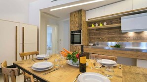 Une cuisine moderne avec des meubles en bois, un four encastré et un évier en acier inoxydable.