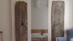 Une pièce comprenant un lit, une chaise et deux grands panneaux en bois sur le mur.
