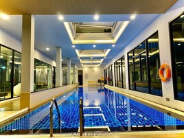 Una piscina techada, sillones reclinables de piscina