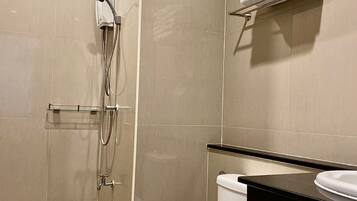 Un baño moderno con inodoro, lavamanos y ducha.