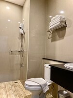 Un baño moderno con inodoro, lavamanos y ducha.