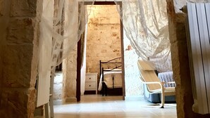 A narrow hallway with stone walls and a white door at the end. - Villa Valentina - Authentic Stone House in the heart of Puglia (Cisternino)