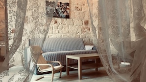 A cozy room with a brick wall, a cushioned bench, a wooden table, and sheer curtains. - Villa Valentina - Authentic Stone House in the heart of Puglia (Cisternino)