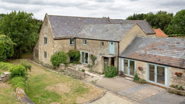 A stone house with a sloped roof, a gravel driveway, and a small garden area. - Secret Garden studio at Woodcock Farm (Bristol)
