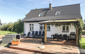 Enjoy outdoor dining or relaxation on the covered patio with comfortable seating and a garden view.