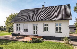 Step up to the charming entrance of this two-story house, surrounded by a beautifully maintained lawn and garden.