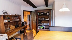 A rustic kitchen with wooden furniture, a dining table, and a variety of kitchen utensils and dishes. - Holiday house sunny and rustic, 2-8 P, in Val Poschiavo (Poschiavo)