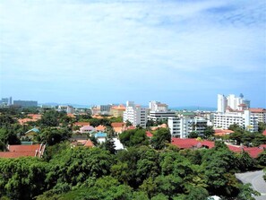 A coastal cityscape with a mix of residential and commercial buildings, including high-rise hotels and smaller structures. - Sea View Studio at View Talay (Pattaya)