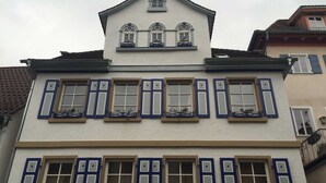 A two-story building with a symmetrical facade, featuring a central balcony with railings and multiple windows with shutters. - Vacation apartment A, Salzgasse, Old Town - Edition Bad Wimpfen (Bad Wimpfen)