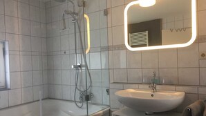 A modern bathroom with a glass-enclosed shower, a white sink, and a mirror with a lighted frame. - Vacation apartment A, Salzgasse, Old Town - Edition Bad Wimpfen (Bad Wimpfen)