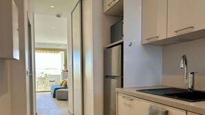 Eine moderne Küche mit einem Edelstahl-Kühlschrank, einer Spüle und einer Arbeitsfläche.