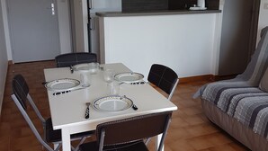 Ein kompakter Wohnbereich mit Essplatz, Küchenzeile und einer Couch.
