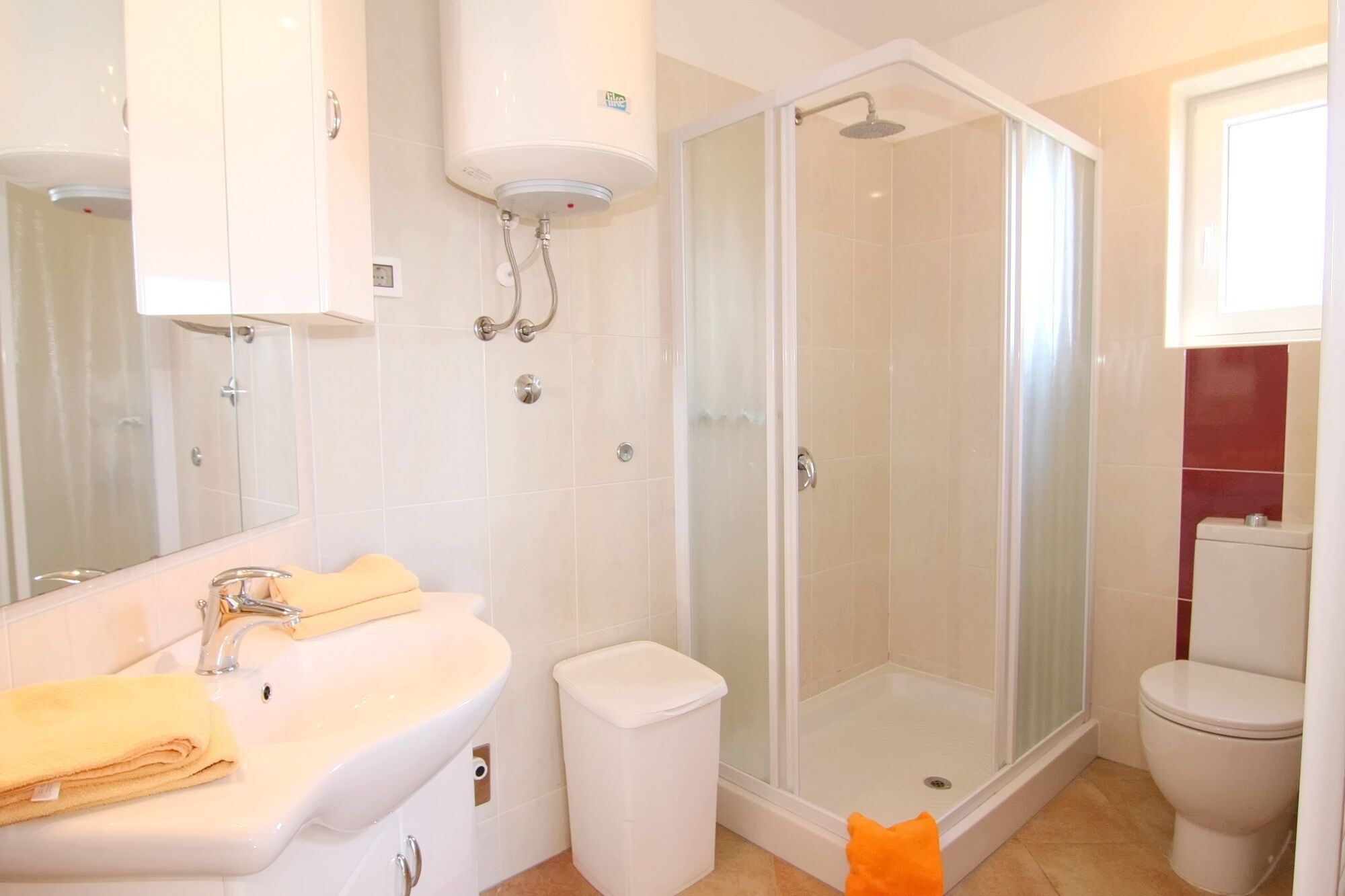 A modern bathroom with a glass-enclosed shower, a sink with a mirror, and a toilet.