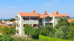A two-story house with a red-tiled roof, multiple chimneys, and a balcony. - With sea view in Apartment Bernstein in Porec. (Porec)