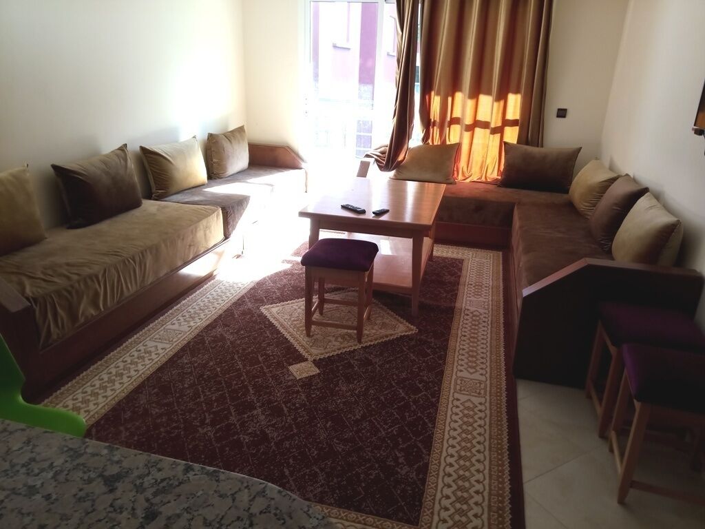 A living room with a sofa set, a coffee table, and a patterned rug.