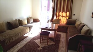 A living room with a sofa set, a coffee table, and a patterned rug.