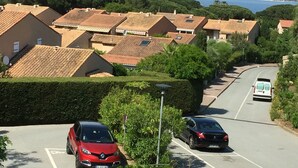 A residential street with houses, parked cars, and a clear view of the sea and hills in the background. - T2 Mezzanine in Ste Maxime Gulf of St Tropez (Sainte-Maxime)