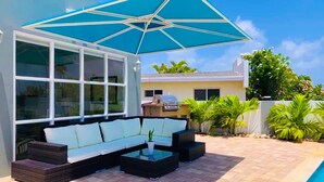 A patio with a sofa, coffee table, and umbrella. - Romantic, Beautiful Sunsets w/Private Pool (West Punt)