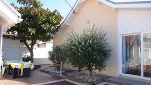 A patio area with a table and chairs, a small tree, and a potted plant. - Villa familiale avec chalet proche centre et plage (044) (Biscarrosse)