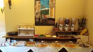 A buffet setup with various food items and condiments. - B&B Le Vie del Borgo (Castiglione di Sicilia)