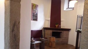 A rustic interior with a stone fireplace, wooden beams, and a tiled floor. - B&B Le Vie del Borgo (Castiglione di Sicilia)