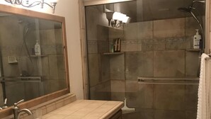 A bathroom with a sink, mirror, shower, and towel rack. - Beautiful  Spacious Suite w/private entrance (Bishop)