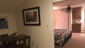 A bedroom with a bed, a nightstand, a dresser, and a door leading to a bathroom. - Beautiful  Spacious Suite w/private entrance (Bishop)
