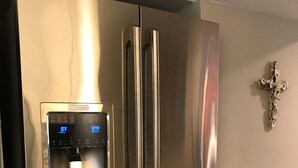 A stainless steel refrigerator with a water dispenser and a freezer drawer.