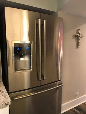 Kitchen features a refrigerator with water dispenser and digital display.