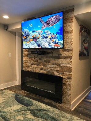 Relax in this stylish living room with a flat-screen TV and comfortable seating area.